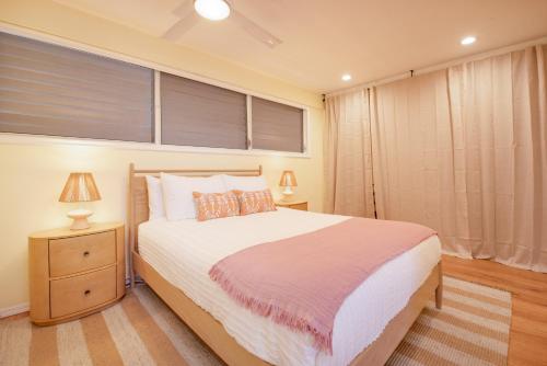 a bedroom with a bed and a window with blinds at Kailani Kona-Ocean view, top floor Downtown w pool in Kailua-Kona