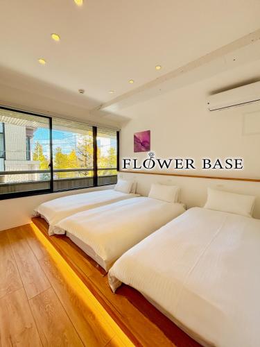 two beds in a bedroom with a sign that reads flower base at Flower Base HIMAWARI in Fukuoka