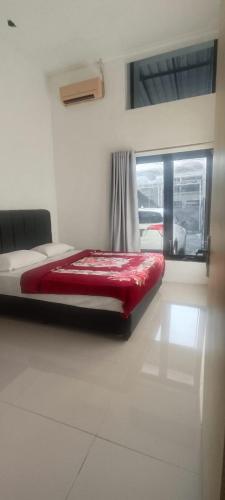 a red bed in a room with a window at Adah 786 Villa Syariah in Krian