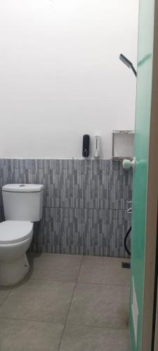 a bathroom with a toilet and a phone on the wall at Adah 786 Villa Syariah in Krian