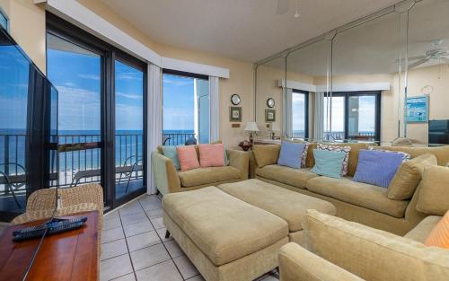 a living room with two couches and a balcony at Phoenix VI 61204 in Orange Beach
