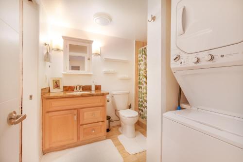 a white bathroom with a toilet and a sink at Kailani Kona-Ocean view, top floor Downtown w pool in Kailua-Kona