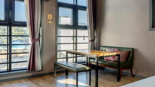 a table and chairs in a room with a window at Samcheok Lamer Pension in Samcheok