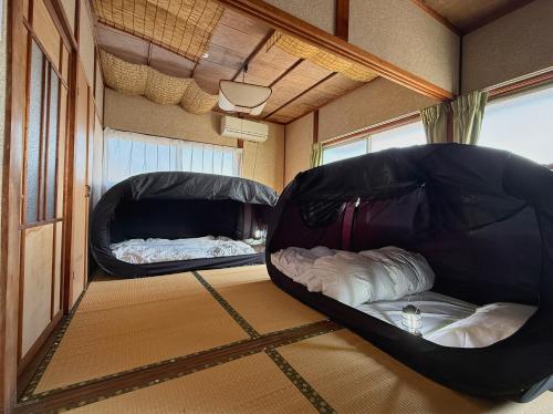 two beds in the middle of a room at Hareumi in Tamano