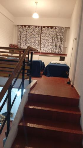 a stairway leading to a room with a bed and a window at Triplex waltito in San Clemente del Tuyu