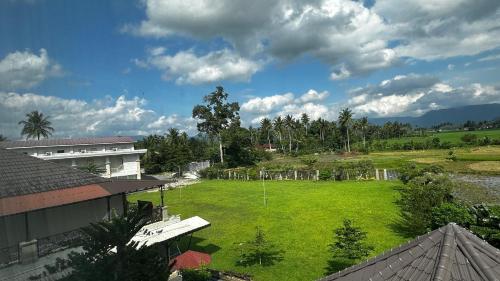 a large green field next to a building at Hotel Mangkuto Syariah in Payakumbuh