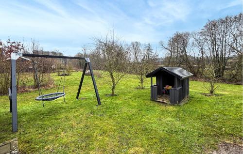 a playground with a swing and a play structure at Lovely Home In Haderslev With Sauna in Haderslev