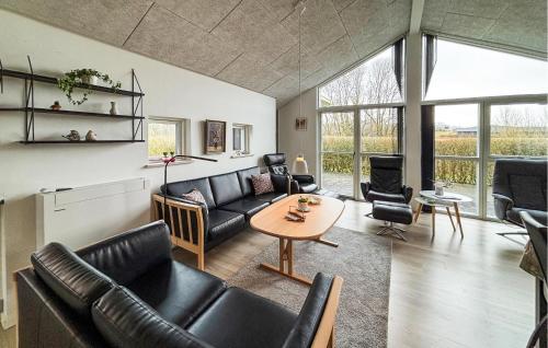 a living room with black leather furniture and a table at Lovely Home In Haderslev With Sauna in Haderslev