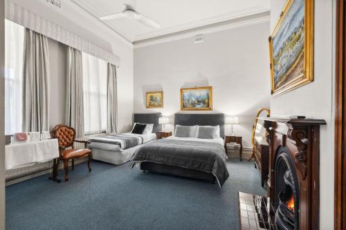 a bedroom with a bed and a couch and a chair at Lancefield Guest House in Lance Field