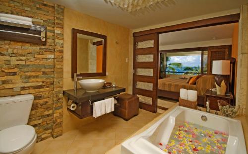 a bathroom with a toilet and a bath tub at Costabella Tropical Beach Hotel in Mactan