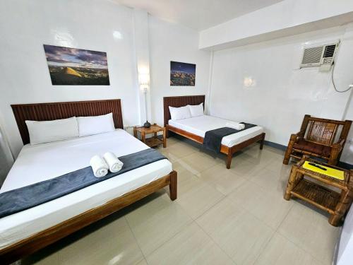 a hotel room with two beds and a chair at Matilde B&B - La Paz, Carmen in Carmen