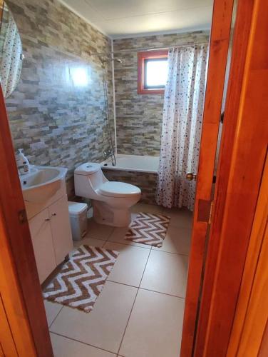 a bathroom with a toilet and a sink at Hospedaje Fer-Mar in Castro