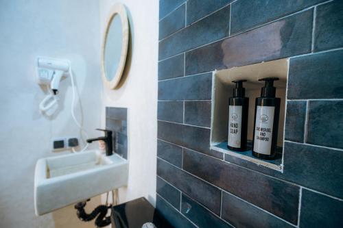 a bathroom with a sink and two bottles of wine at Surf Lodge Tamraght in Tamraght Ouzdar