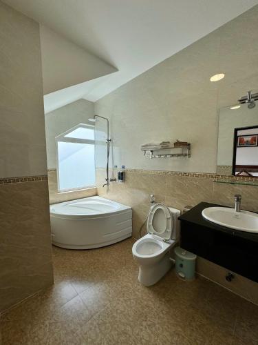 a bathroom with a toilet and a sink and a shower at Tomy Khe Sanh Đà Lạt in Ấp Ða Lợi