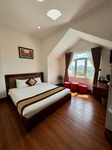 a bedroom with a large bed and a large window at Tomy Khe Sanh Đà Lạt in Ấp Ða Lợi