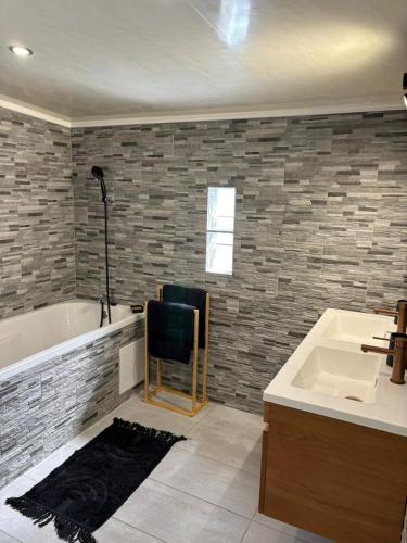 a bathroom with a sink and a bath tub at Villa hibiscus in Sainte-Suzanne