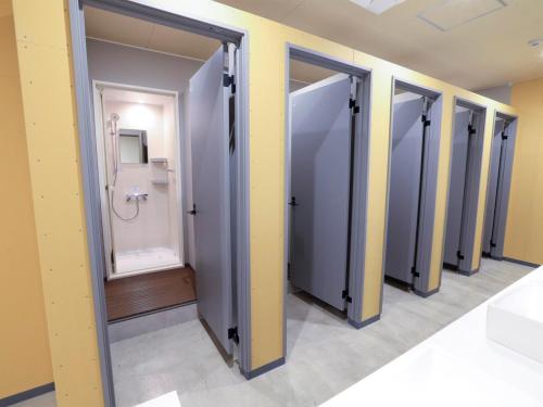 a row of stalls in a bathroom with a toilet at Cabin kutekun in Naka-shibetsu