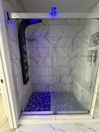 a shower with a glass door with purple tiles at Beautiful Colonial in the Poconos in Tobyhanna
