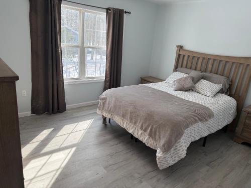 a bedroom with a bed and a large window at Beautiful Colonial in the Poconos in Tobyhanna