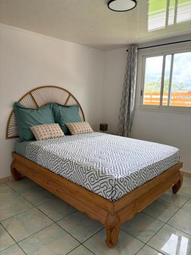 a bedroom with a wooden bed with a window at Villa hibiscus in Sainte-Suzanne
