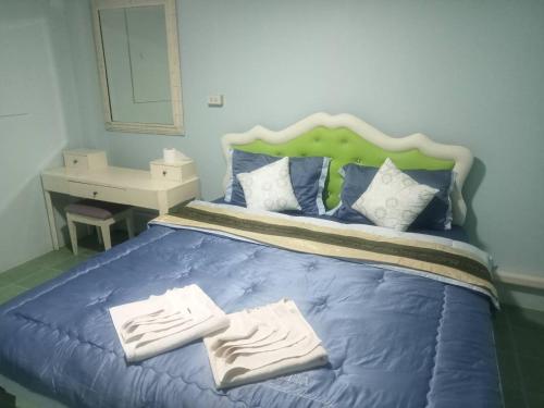 a bedroom with a blue bed with two towels on it at Sairung Farmstay and Cawboy Krabi in Ban Nua Khlong