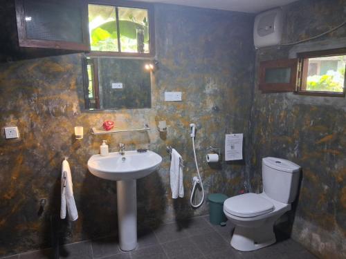 a bathroom with a toilet and a sink at Mallis Guesthouse in Habaraduwa Central