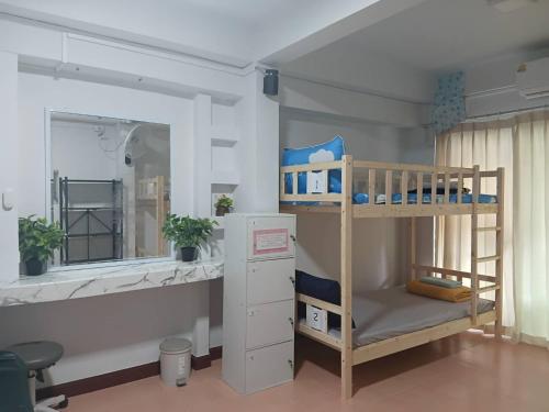 a bedroom with two bunk beds and a mirror at Middle Road Hostel in Nathon Bay