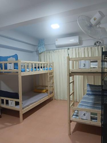 a room with two bunk beds and a fan at Middle Road Hostel in Nathon Bay