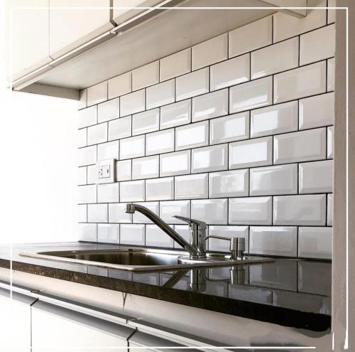 a kitchen with a sink and a white tiled wall at Quinta Soñada Junin in Junín