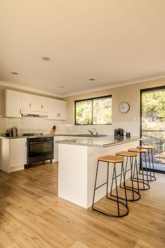 an open kitchen with white counters and bar stools at The Canopy in Albany