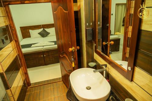 a bathroom with a sink and a bed and a mirror at T P Villas in Nilaveli