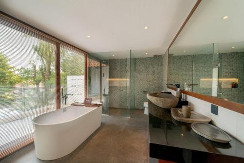 a bathroom with a tub and a large window at SEA TO SKY Villa - 4 Bedrooms Ocean View in Pulau Nongsa