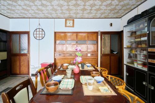 a kitchen with a wooden table with chairs and a dining room at OMOTENASHI LODGE Yuyu - Vacation STAY 11761 in Nakafurano