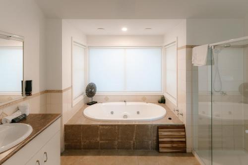 a bathroom with a bath tub and a window at Shambala Estate Cottages in Mount Tamborine