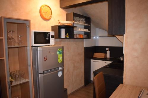 uma pequena cozinha com frigorífico e micro-ondas em Apartment Borovnica em Moravske Toplice