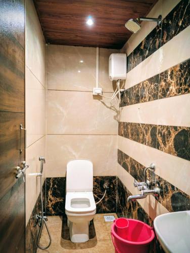 a bathroom with a toilet and a sink at Hotel Rukmini Residency, Kolhapur in Kolhapur