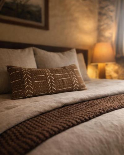 a bed with a brown pillow on it with a lamp at La Casa del Guamúchil in Tequesquitengo