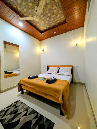 a bedroom with a large bed with a wooden ceiling at Hotel Rukmini Residency, Kolhapur in Kolhapur