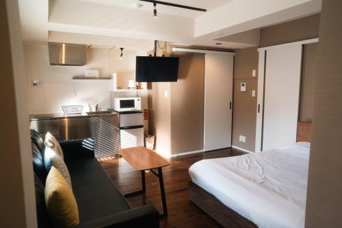 a room with a bed and a couch and a kitchen at Condominium MIRAHAKONE in Hakone