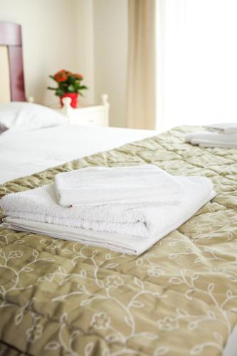 a pair of towels sitting on top of a bed at Hotel Zografos in Paralia Katerinis