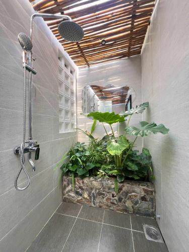 a bathroom with a shower with plants in it at Bến Đò Xưa Homestay & Coffee in Cái Răng