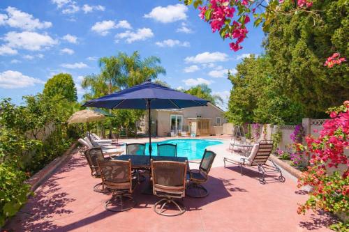 a table with chairs and an umbrella next to a pool at Disneyland Paradise 6 BedRoom 4 Bathroom Pool Spa Games in Anaheim