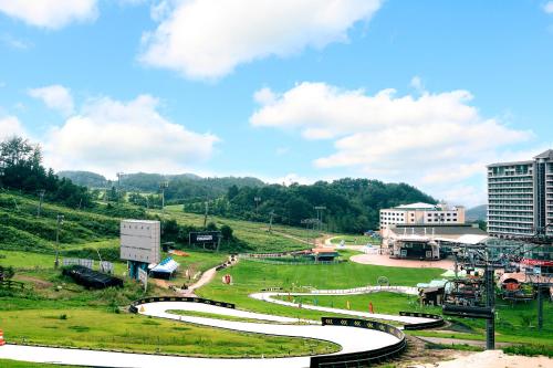 a view of a park with a river and buildings at Wellihilli Park Resort in Hoengseong