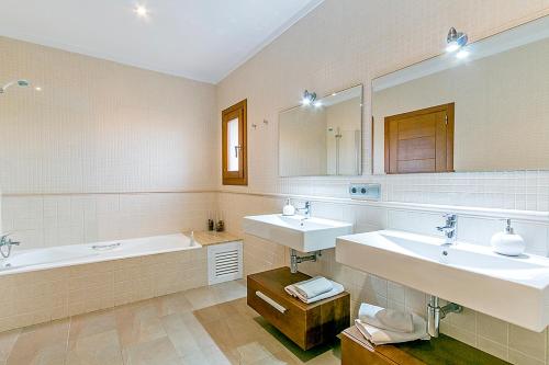 a large bathroom with two sinks and a bath tub at Finca Santa Maria in Alcudia