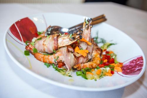 a plate of food with shrimp and vegetables on a table at Hotel Zografos in Paralia Katerinis