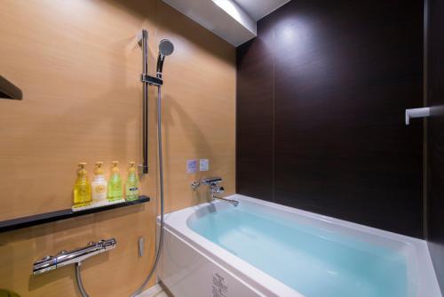 a bathroom with a bath tub with a shower at Hotel COREST (Adult Only) in Tokyo