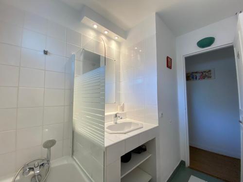 a white bathroom with a sink and a shower at Quiet Stay near Paris - Balcony & Private Parking in Châtillon