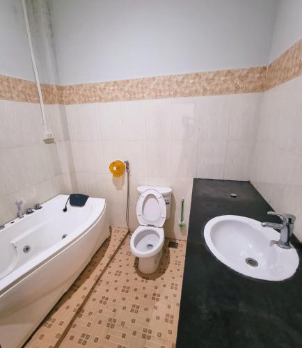 a bathroom with a tub and a toilet and a sink at Beyond Pub guest House and Hotel in Ban Tayun