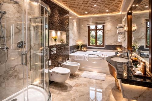 a bathroom with a tub and a toilet and a sink at Mascot Houseboats in Srinagar