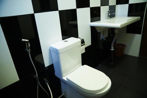 a bathroom with a white toilet and a sink at Kandy Moon Hills Hotel in Kandy